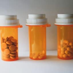 three orange pill bottles in a row