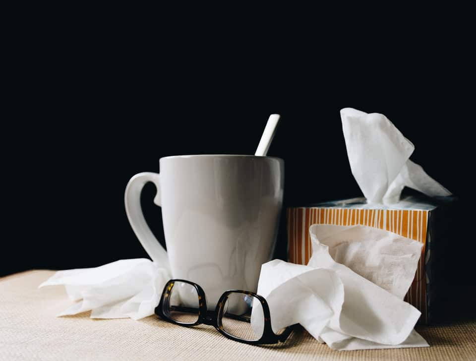 A mug, some tissues and a pair of glasses.