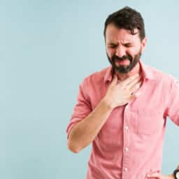 Man holding his chest experiencing heartburn