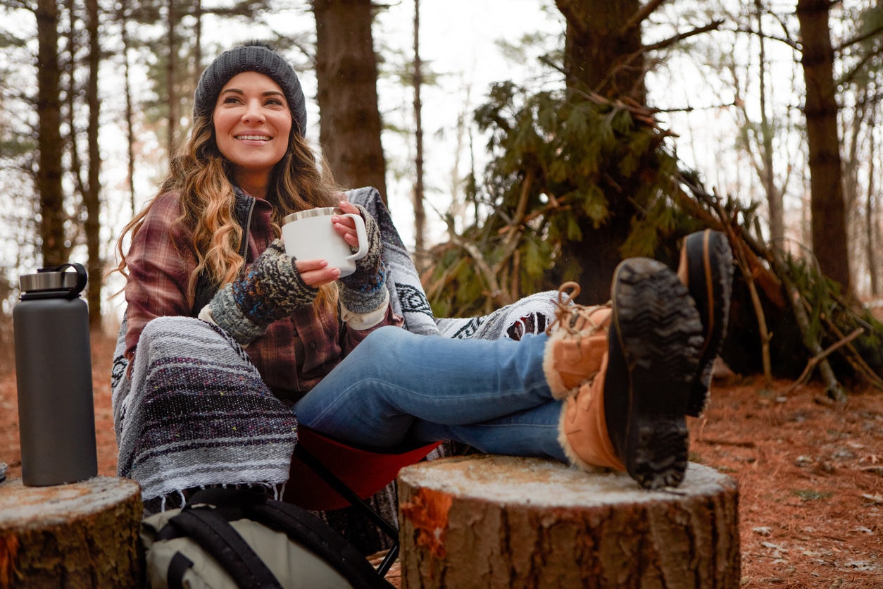 Woman having coffee on a chilly hiking trip.