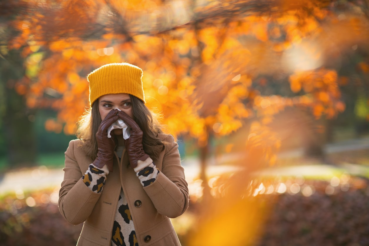 Woman blows nose in the fall