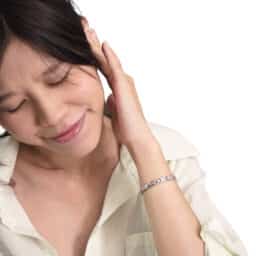 Woman with ear pain holds ear