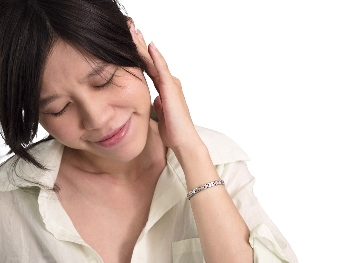 Woman with ear pain holds ear