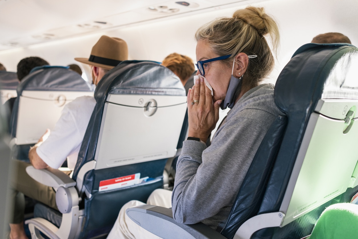 Woman blows nose on plane