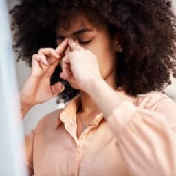 Woman with sinus pressure massaging the bridge of her nose