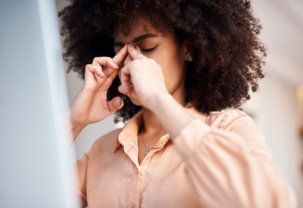 Woman with sinus pressure massaging the bridge of her nose.