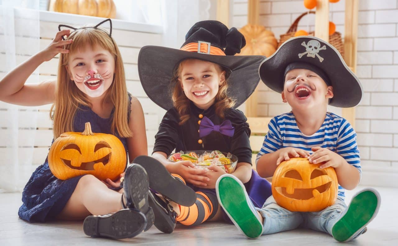 Three young kids in Halloween costumes.