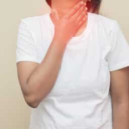 Woman holding her inflamed throat