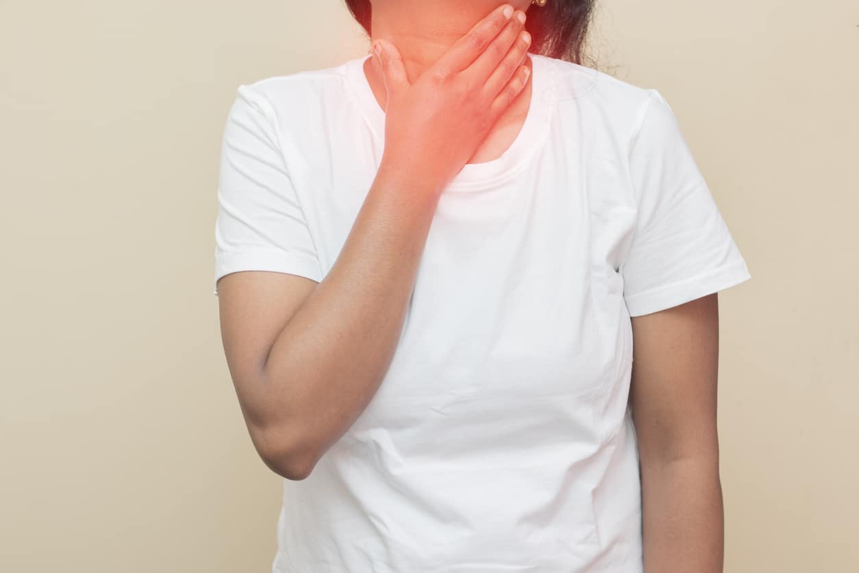 Woman holding her inflamed throat.